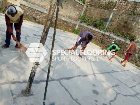 pembersihan lapangan sebelum pekerjaan pengecatan lapangan badminton